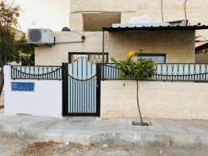 a house with a black gate and a plant at Jerash sky1 in Jerash