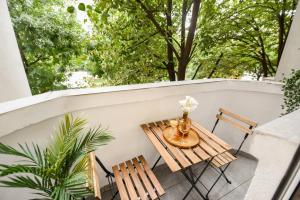 un tavolo e sedie su un balcone alberato di Ideal Home - Spacious & Modern Accommodation near Unirii Square a Bucarest