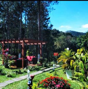 um jardim com um gazebo e flores em Recanto de Moriá em Penedo