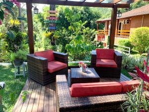 a patio with two chairs and a couch on a deck at Recanto de Moriá in Penedo