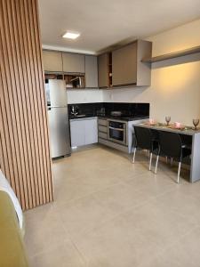 una cucina con frigorifero, tavolo e sedie di Studio no centro com piscina a Juiz de Fora Altre 2 foto