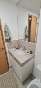 un bagno con lavandino e specchio di Studio no centro com piscina a Juiz de Fora