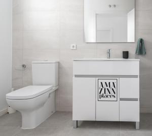 a white bathroom with a toilet and a sink at Habitacion a metros de la playa con cocina y WC compartida, terraza y zonas comunes in Valencia