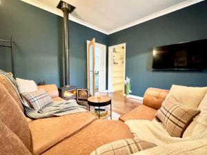 a living room with a couch and a fire place at Chestnut Cottage in Dalmellington