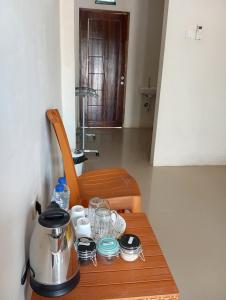 a table with a tea kettle and glasses on it at WL GUESTHOUSE in Labuan Bajo