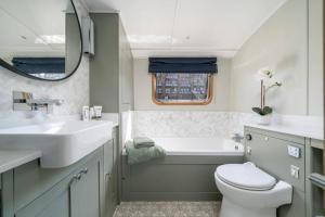 Un baño con lavabo, bañera e inodoro. en Luxurious houseboat near Canary Wharf in London, en Londres