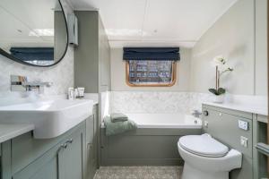 a bathroom with a sink and a tub and a toilet at Luxurious houseboat near Canary Wharf in London in London