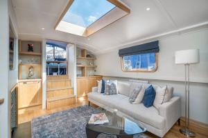 una sala de estar con un sofá y una mesa en Luxurious houseboat near Canary Wharf in London, en Londres