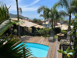 una piscina en una terraza de madera con palmeras en Pousada Mirante, en Florianópolis