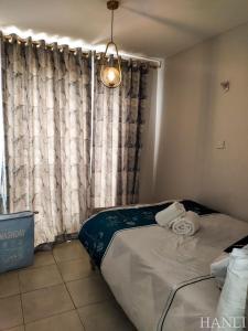 - une chambre avec un lit et une fenêtre avec des rideaux dans l'établissement 1 Bdr apartment with pool, à Nairobi