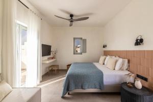 1 dormitorio con 1 cama, TV y sofá en Nysis Koufonisia en Koufonisia