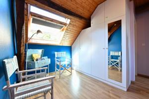 um quarto com paredes azuis, uma janela e cadeiras em Le mouly/grand gite em Miossens-Lanusse