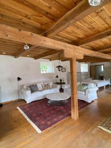 a living room with white couches and a wooden ceiling at ÖsterlenUpplevelser i Gladsax på Österlen in Simrishamn