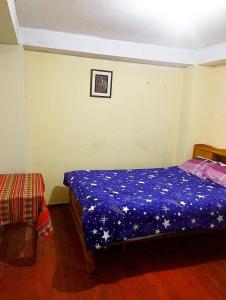 a bedroom with a bed with a blue comforter at Cruz Apartments - Centro Histórico de Cusco in Cusco