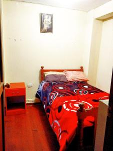 a bedroom with a bed with a red and blue blanket at Cruz Apartments - Centro Histórico de Cusco in Cusco