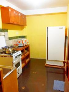 a kitchen with a stove and a white refrigerator at Cruz Apartments - Centro Histórico de Cusco in Cusco