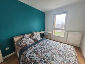 a bedroom with a bed and a blue wall at Cozy apartment at Paris doors with free car-park in Saint-Denis +6 photos