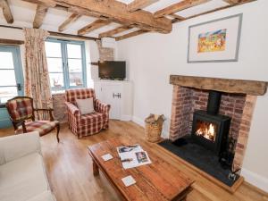 a living room with a brick fireplace at Tannery Cottage in Much Wenlock