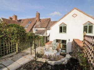 a bedroom house with a garden and a fence at Tannery Cottage in Much Wenlock