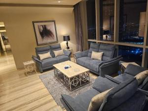 ein Wohnzimmer mit Sofas und einem Tisch in der Unterkunft Luxury Towers Apartment in Downtown in Riad