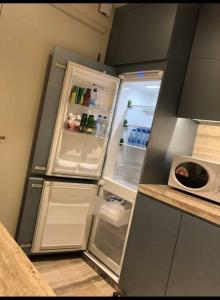 a refrigerator with its door open in a kitchen at Luxury Towers Apartment in Downtown in Riyadh