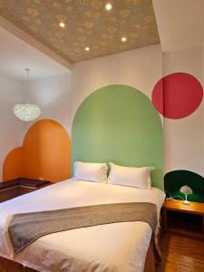 a bedroom with a bed with red and green walls at 覓思旅Miss inn in Hengchun South Gate