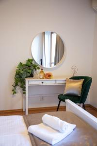 a mirror in a room with a table and a chair at Hotel Rozálka in Pezinok