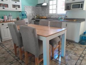 uma cozinha com uma mesa de madeira e cadeiras em Hostel Mia em Ezeiza