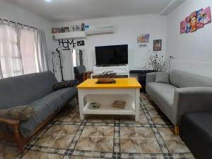 ein Wohnzimmer mit 2 Sofas und einem Tisch in der Unterkunft Hostel Mia in Ezeiza