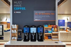 a coffee shop with a bunch of bottles on a counter at Holiday Inn Express Hotel & Suites Rochester Webster, an IHG Hotel in Webster