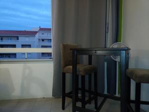 einen Tisch und zwei Stühle in einem Zimmer mit Fenster in der Unterkunft MER, BATEAUX, Canaux in Sète