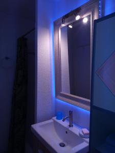 ein Bad mit einem Waschbecken und einem Spiegel in der Unterkunft MER, BATEAUX, Canaux in Sète