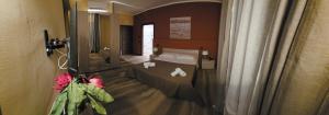 Pozzolo FormigaroにあるHOTEL BIJOUXのベッドと鏡が備わるホテルルーム