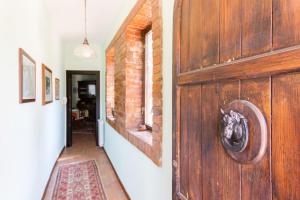 a hallway with a wooden door and a brick wall at Don Ciccio Sea House in Carini
