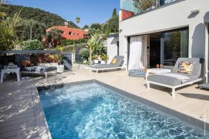 une terrasse avec une piscine et une maison dans l'établissement Deluxe VILLA GRAZIELLA 200 M FROM THE BEACH, à Èze