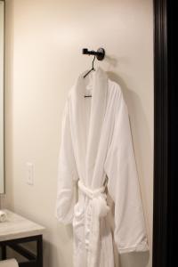 a white robe is hanging on a wall at Hotel Emeline in Charleston