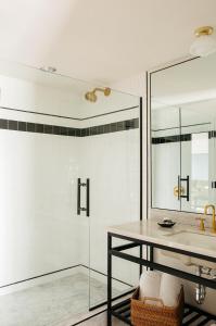 a bathroom with a glass shower and a table at Hotel Emeline in Charleston