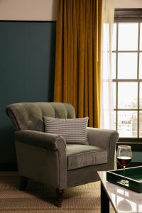 a living room with a couch and a glass of wine at Hotel Emeline in Charleston