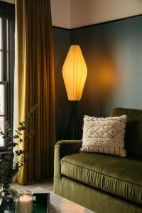 - un salon avec un canapé et une lampe dans l'établissement Hotel Emeline, à Charleston