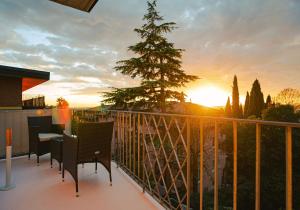 un balcón con mesa, sillas y un árbol en Maison Temple, en Verona