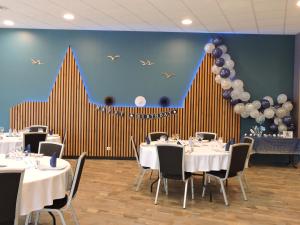 un comedor con mesas y globos en la pared en Hôtel Le Kolibri en Tournus