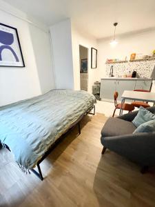 a bedroom with a bed and a couch in a room at STUDIO Retro MARAIS- Paris Center in Paris