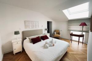 um quarto com uma grande cama branca e uma clarabóia em Nice 120m With Large Terrace In Blagnac! em Blagnac