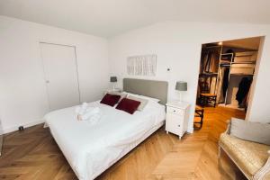um quarto com uma grande cama branca com almofadas vermelhas em Nice 120m With Large Terrace In Blagnac! em Blagnac