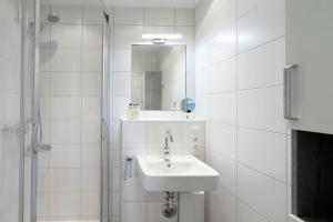 a white bathroom with a sink and a mirror at Sonnenidyll in Westerland +26 photos