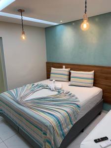 a bedroom with a large bed with two pillows at Pousada Beija Flor in Maceió