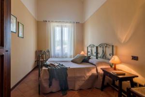 ein Schlafzimmer mit einem Bett und einem Fenster in der Unterkunft Casale Nocciolo in Bevagna + 27 Fotos