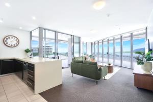 an office with a desk and a chair and a clock at 11 Harbour Lights with Ocean Views in Cairns
