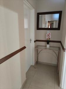 a hallway with a mirror and a table with flowers at Unit 89 Pendleberry Holiday Resort in Bela-Bela