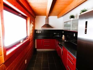 a kitchen with red cabinets and a window at Zrub Alpinus in Pribylina